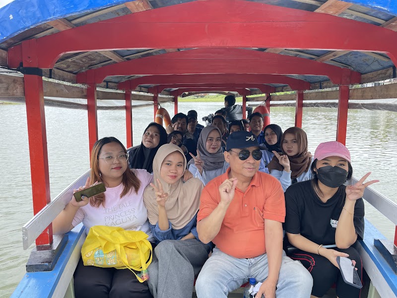 Anggota tim SMC berfoto bersama di atas perahu saat family gathering