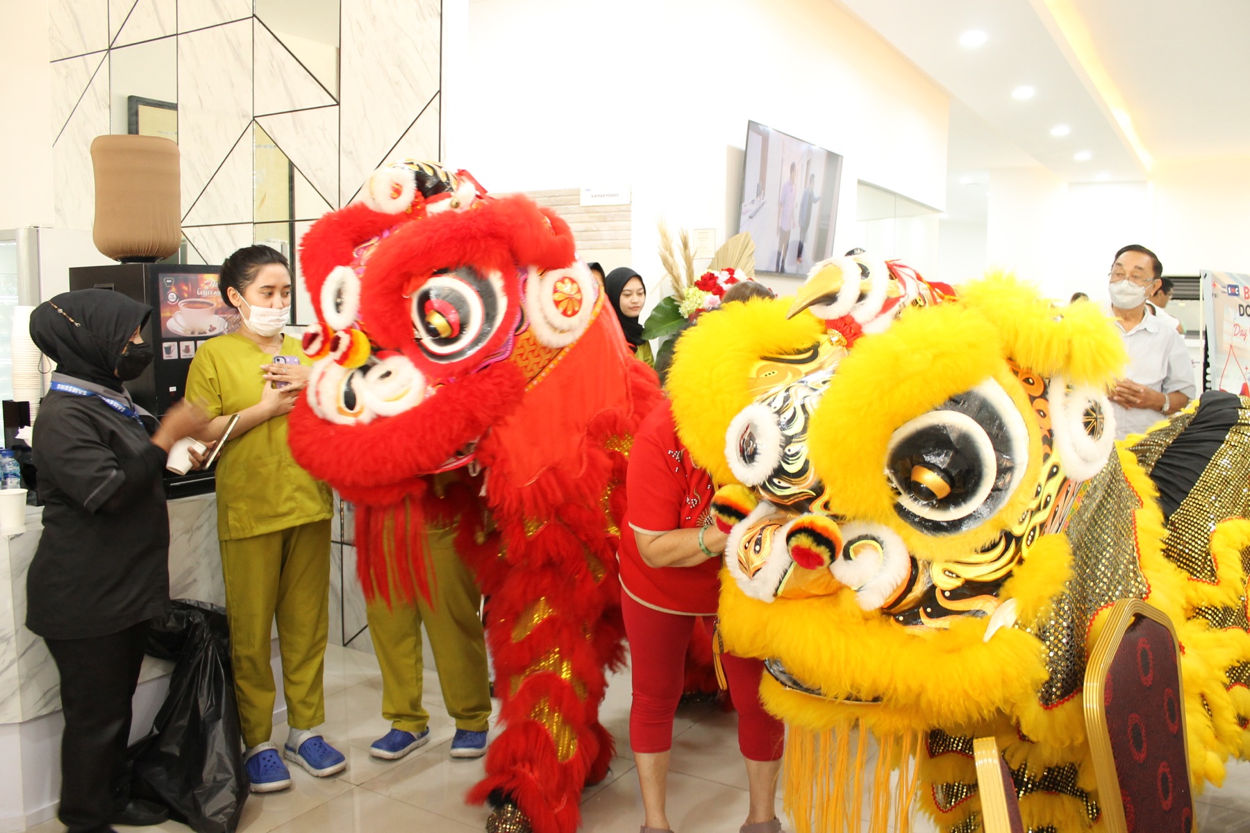 Pertunjukan barongsai merah dan kuning di grand opening Klinik Utama SMC